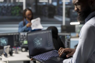 Bilgisayardaki yapay zeka görselleştirme araçlarıyla veri merkezi yönetimi ekipman hatalarını tespit ediyor. Yapay zekaya bakan sunucu merkezi çalışanı donanım arızalarını tespit etmek için dizüstü bilgisayarda içgörü oluşturdu