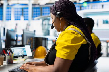 Siyah fabrika teknisyeni, güneş paneli çağrı merkezinden destek ve sorun giderme için yardım hattı taleplerini yönetmeyi teklif ediyor. Müşteri hizmetleri asistanı işlemleri geliştirir.