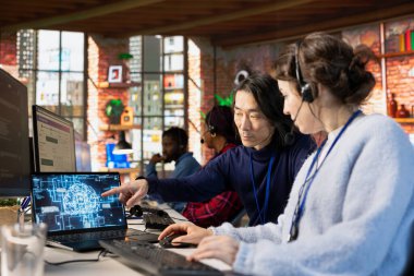 Çağrı Merkezi kıdemli müdürü yapay zeka sohbet robotunun nasıl kullanılacağı konusunda stajyer doktorlara rehberlik ediyor. Yeni işçiye AI LLM asistan kullanmayı öğreten Asyalı müşteri destek işyeri