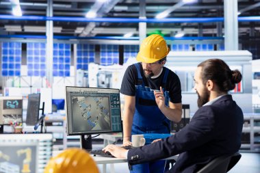 Mühendislik ekibi güneş paneli üretim tesisi montaj hatlarını izlemek için PC kullanıyor. Takım çalışanı iş arkadaşları sorunlu fotovoltaik ekipmanlarla sorunlu çekim yaparak sorunsuz üretim akışını sağlıyorlar.