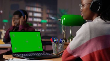 Genç öğrenci sınav hazırlıkları için araştırma yaparken, güvenilir akademik kaynaklardan eğitim bilgileri okurken, modelleme sergisi kullanır. Öğrenci notlarını ders kitabında tamamlar. Kamera A.