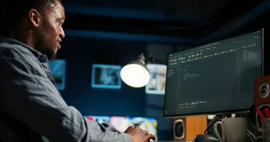 Geliştirici, Html kodunu kurarken terminal paneline ikili veri girer. Yazılım mühendisi, programlama dili ve şifreleme ile sorun çözmede evden çalışıyor. Kamera A.