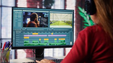Video yapımcısı kadın, zaman çizgisi düzenleme ve renk derecelendirme arasında çift monitörlü bir video düzenliyor. Profesyonel editör teknolojik araçlar ve yazılımlar kullanır. Kamera A.