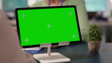 Kurumsal kadınlar, toplantı sırasında finansal verileri, stratejik göstergeleri ve diğer bilgileri değerlendirmek üzere modern çalışma ortamında kroma anahtar gösterimiyle bir araya geliyorlar. Kamera B.