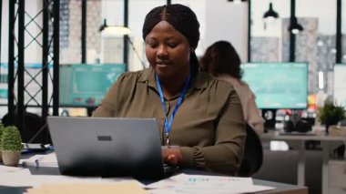 Siyahi şirket yöneticisi belgeleri gözden geçirir ve stratejiyi ayarlar, kilit verileri bilgisayarına aktarır. Proje geliştirme ve tamamlama için kaynak tahsis ediliyor. Kamera B.