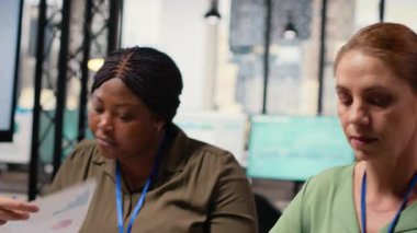 Kararlı kadın CEO bilgisayarındaki grafikleri ve performans raporlarını gözden geçirir. Modern bir şirket ofisinde kadın yöneticilerle buluşup iş büyümesine olan bağlılığını garantiler. Kamera B.