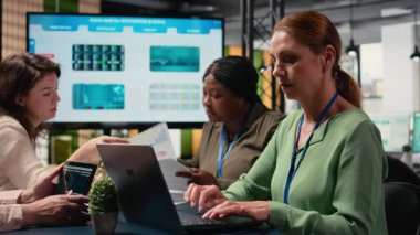 Kararlı kadın CEO bilgisayarındaki grafikleri ve performans raporlarını gözden geçirir. Modern bir şirket ofisinde kadın yöneticilerle buluşup iş büyümesine olan bağlılığını garantiler. Kamera A.