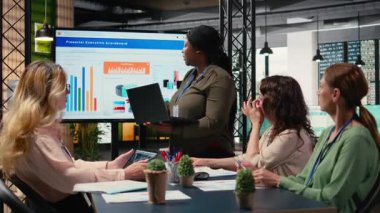 Yönetici yöneticisi, mali durumu TV ekranında sunuyor. İş arkadaşlarıyla geliştirme ve problem çözme konularını tartışıyor. Tüm bayan takımlar brifing oturumunda. Kamera A.