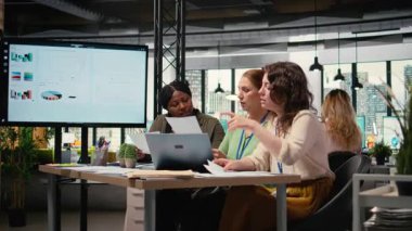 İş kadınları, analitik ve plan stratejilerini modern bir çalışma alanında, birlikte geliştirme vizyonunu destekleyerek karşılaştırırlar. Veri analizlerinde işbirliği yapan ve gözden geçiren çeşitli ortaklar. Kamera A.