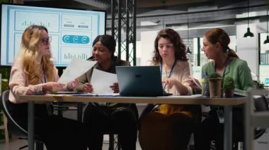 Brifing sırasında işbirliği yapan, veri analizi yapan ve raporlar yazan bir grup iş kadını bir büyüme zihniyetini benimserler. Hedefe yönelik toplantı. Kamera A.