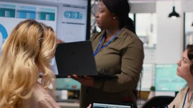 Afrika kökenli Amerikalı bir kadın iş arkadaşlarıyla fikirlerini paylaşıyor başarılı bir işletme yönetiminin geleceğini güvence altına almak için çalışıyor. TV ekranındaki finans verilerini inceliyorum. Kamera B.