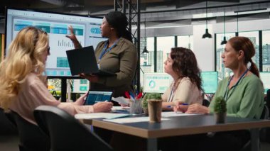 Afrika kökenli Amerikalı bir kadın iş arkadaşlarıyla fikirlerini paylaşıyor başarılı bir işletme yönetiminin geleceğini güvence altına almak için çalışıyor. TV ekranındaki finans verilerini inceliyorum. Kamera A.