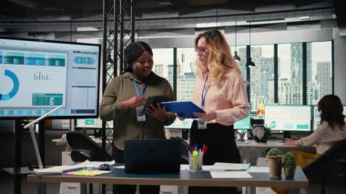 Çeşitli kadın profesyoneller, rekabetçi bir çalışma ortamında başarı hedefleri ve kararlılığı yoluyla güçlendirme göstererek, ofiste rapor yazma ve analizlere odaklanıyorlar. Kamera A.