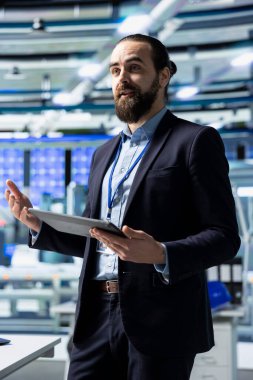 Profesyonel müfettiş, toplantı sırasında çalışanları ve yardımcılarıyla konuşuyor, montaj ve üretim hattıyla ilgili görüşlerini paylaşıyor. Enerji endüstrisi için sürdürülebilir çözümler gözden geçiriliyor.