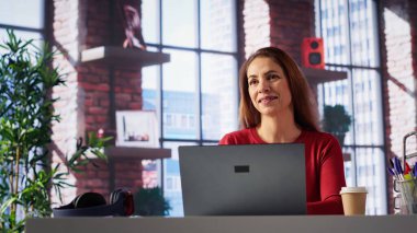 Kendine güvenen bir kadın evdeki serbest bir platformda görevlerini çözüyor, e-postaları cevaplıyor ve birden fazla iş yapıyor. Olgun işçi bağlı kalır ve uzaktan çalışmanın esnekliğinin tadını çıkarır. Kamera A.