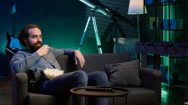 Neşeli ev sahipleri TV 'yi komedi filmleri izlemek için kullanıyor, komik şakalara gülüyorlar. Ev sinemasında ışıl ışıl parlayan, mizahi film sahnesiyle eğlenen, kamera A