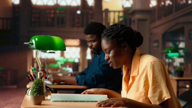 Yaklaşan sınava çalışmak için çabalayan, kütüphanedeki kuramsal notları ezberlemeye çalışan üzgün bir kız. Notlarıyla ilgilenen siyahi bir üniversite öğrencisi. Kamera.