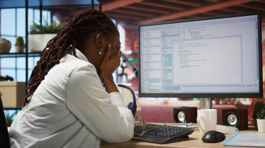 Sıkılmış yazılım geliştirici kodlama sırasında hayal kırıklığına uğradı, algoritmaları uygulamakta zorlanıyor. Mutsuz bilişim uzmanı kod düzenleyicisi ile çalışırken sinirlendi, performansı optimize edemiyor, kamera A