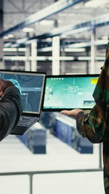 Düşman tehditlerini izlemek için radar yazılımına bakan askeri veri merkezi meslektaşlarının dikey videosu. Veri merkezindeki ekip çalışanları şüpheli aktiviteleri tespit etmek için tarıyorlar.