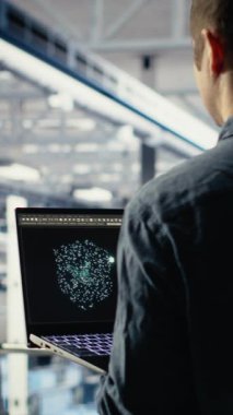 Veri merkezindeki dikey video yazılım geliştiricisi, rutin sistem incelemesi sırasında dizüstü bilgisayarını kullanarak Al 'ın gösterge panelini kontrol ediyor. Sunucu merkezi IT uzmanı performansı kontrol etmek için yapay zekayı dizüstü bilgisayarda test ediyor