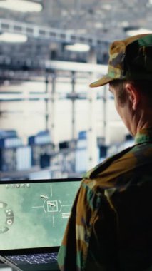 Veri merkezindeki dikey video askeri teknisyeni defter yazılım arayüzü kullanarak uydu koordinatlarını takip ediyor. Sunucu merkezindeki ordu birimi uydu görüntüleme yoluyla keşif verilerini analiz ediyor.