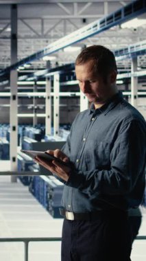 Dikey video Veri Merkezi teknisyeni makine öğrenme sürecini tabletle izleyip işlevsel ölçümleri gözden geçiriyor. İnceleme sırasında sinirsel ağ raporlarını incelemek için aygıt kullanan bilişim uzmanı, kamera A