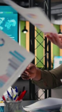 Bir brifing toplantısında veri paylaşımı, güçlü bir şirket vizyonu ve başarı hedefleri oluşturmak için fikir alışverişinde bulunan dikey video çeşitliliği iş ortakları. Hırslı bayan meslektaşlar. Kamera A