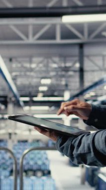 Dikey video sunucu odası çalışanı sistem sağlığını izlemek için tabletteki veri tabletlerini kontrol ediyor. Sistem yöneticisi veri merkezinin iş hedefleri ve müşteri ihtiyaçları olan kamera A 'yı karşıladığından emin olmak için grafikleri gözden geçirir