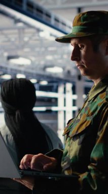 Sunucu odasındaki dikey video askeri ve mühendis bilgisayar sistemlerini yönetmek için yapay zeka araçları kullanıyor. Ordu komutanı ve kadın programcı sunucudaki yapay zekayı kullanarak bilgileri gözden geçirir