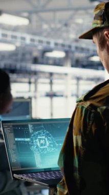 Mühendislik rolündeki dikey video askeri sunucu merkezi sistemlerini yönetmek için dizüstü bilgisayardaki yapay zeka uygulamasını kullanır. Ordu komutanı, gizli istihbarat bilgilerini yapay zeka kullanarak inceliyor.