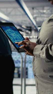 Dikey video veri merkezi sistem yöneticilerinin sondaj platformlarına derin öğrenme yazılımı yerleştirmesi. Sunucu merkezi bilişim uzmanları ekibi, uygulamaları desteklemek için tablet kullanan veri tabanlı yapay zeka sistemleri eğitiyorlar.