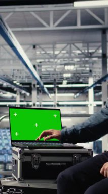 Dikey Veri Merkezi çalışanları sistem incelemesi sırasında yeşil ekran dizüstü bilgisayar kullanarak Al 'ın gösterge panelini kontrol ediyorlar. Sunucu merkezi çalışanları yapay zeka araçlarını güvenilir bir defter için test ediyor