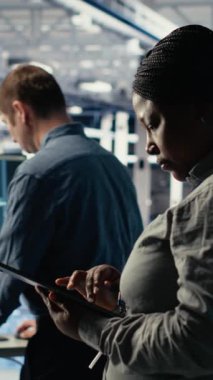 Veri merkezi teknisyenlerinden oluşan dikey video ekibi sistem incelemesi sırasında dizüstü bilgisayarı kullanarak Al 'ın gösterge panelini kontrol ediyor. Takım çalışması sunucu merkezi meslektaşları yapay zeka araçlarını not defteri, kamera B 'de test ediyor.