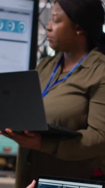 Dikey Afrikalı Amerikalı kadın iş arkadaşlarıyla fikirlerini paylaşıyor başarılı bir işletme yönetiminin geleceğini güvence altına almak için çalışıyor. TV ekranındaki finans verilerini inceliyorum. Kamera B.