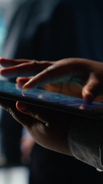 Dikey video Veri Merkezi programcıları yapay zeka panelini tablet kullanarak kontrol eder, sistem gözden geçirir. Sunucu merkezi çalışanları güvenilir performans sağlamak için aygıt üzerinde yapay zeka araçlarını test ediyor, kamera B