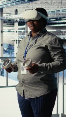 Dikey video veri merkezi bilişim uzmanı sanal gerçeklik kullanarak yapay zeka yapılandırmalarını araştırır ve optimal fonksiyon için ayarlamalar yapar. Sunucu merkezi mühendisi VR kullanarak yapay zeka hatalarını kontrol ediyor