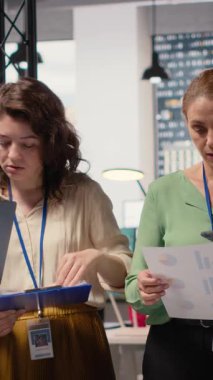 Dikey Video Hırslı ve hedef odaklı çeşitli iş kadınları kurumsal raporları ve grafikleri gözden geçirir, modern bir çalışma ortamında profesyonel büyüme sağlamak için sinerji alanında çalışırlar. Kamera B.