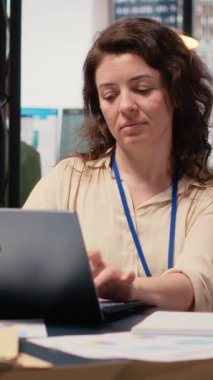 Dikey Video İşkadını kilit performans ölçümlerini değerlendiriyor ve masasında raporlar yazıyor, analitik zihniyetiyle finansal strateji planlıyor. İş faaliyetlerinde profesyonel liderlik