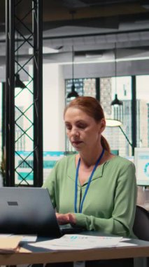 Dikey Video Modern girişimci proje analizlerini ve dizüstü bilgisayarındaki ilerlemesini inceleyerek çalışma yerinde stratejik bir rapor hazırlıyor. Verimlilik ve kariyer geliştirme eylemi gösteriyor. Kamera A