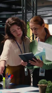 Dikey Video Güçlü çeşitli kadın ekibi modern bir şirket ofisinde proje analizi ve finans raporları üzerinde birlikte çalışarak kararlılık, verimlilik ve ağ oluşturmanın gücünü gösteriyor.