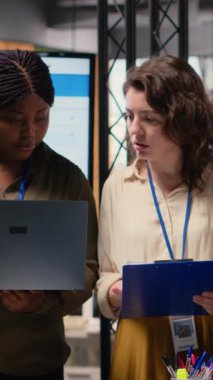 Dikey Video Güçlü çeşitli kadın ekibi modern bir şirket ofisinde proje analizi ve finans raporları üzerinde birlikte çalışarak kararlılık, verimlilik ve ağ oluşturmanın gücünü gösteriyor.