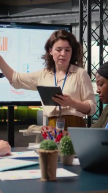 Geliştirme hedefleri olan bir proje planlayan Dikey Video Güçlendirilmiş iş ortakları, çok uluslu şirket büyümesine ilişkin veri içgörüleri ve performans göstergelerini gözden geçirmek üzere bir toplantı odasında bir araya geldiler. Kamera.