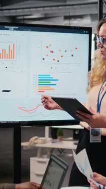 Dikey Video Hırslı CEO, yönetim kurulunda personeline performans göstergeleri sunuyor ve şirket gelişimi için veri raporlarını tartışmak ve analiz etmek için toplanıyor. Brifingdeki güçlü kadınlar. Kamera A.