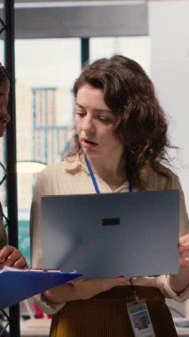 Dikey video çeşitliliğindeki kadınlar proje gelişimini tartışıyor ve kurumsal feminizm ve stratejik hizalama yoluyla elde edilen başarıyı temsil eden canlı bir modern ofiste göstergeler sunuyorlar.