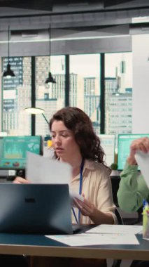 Dikey video çeşitliliğindeki kadınların yeni strateji için biraraya gelmesi ve bilgi alışverişinde bulunması, ofisteki belgelerin grafiklerini gözden geçirmesi. Hedefe yönelik güçlendirilmiş ortam, kurumsal feminizm. Kamera.