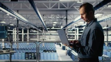 Teknisyen tesiste yürürken laptop kullanarak sunucu odası aktivitelerini izliyor. Veri Merkezi IT profesyonel incelemeleri sistemlerin doğru çalıştığından emin olmak için test sonuçları, kamera A