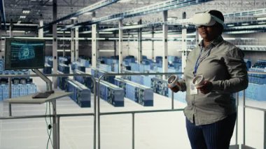 Veri Merkezi IT uzmanı sanal gerçeklik kullanarak yapay zeka yapılandırmalarını inceler ve optimal işlev için ayarlamalar yapar. Sunucu merkezi mühendisi VR kulaklık ve kamera A kullanarak yapay zeka hatalarını kontrol ediyor.