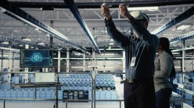 Veri merkezi çalışanı, sistem incelemesi sırasında VR kulaklığı kullanarak Al 'ın gösterge panelini kontrol et. Sunucu merkezi çalışanı sanal gerçeklik teknolojisini kullanarak güvenilir performans için yapay zeka araçlarını test ediyor. Kamera A