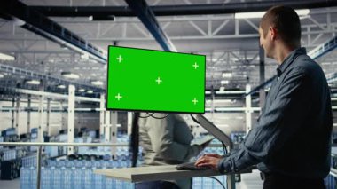 IT uzmanı yeşil ekran çalışma istasyonu kullanarak sunucu çiftlik etkinliğini izliyor. Veri Merkezi Sistem Yöneticisi, sistemlerin düzgün çalıştığından emin olmak için, test sonuçlarının test sonuçlarını gözden geçirir. Kamera A