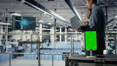 Veri merkezi çalışanları yapay zeka süreçlerini izole ekran tableti ile izleyip ölçümleri gözden geçiriyorlar. Mühendisler, teftiş sırasında yapay zeka raporlarını incelemek için krom anahtar cihazı kullanıyorlar. Kamera A.